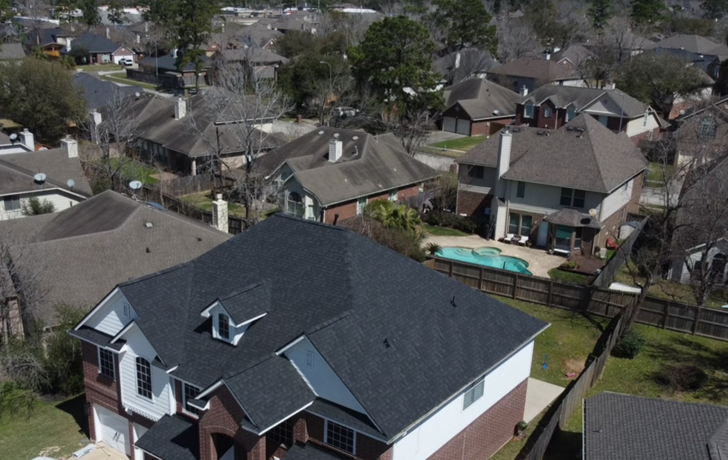 Aerial view of completed residential shingle roof in a Greater Houston neighborhood