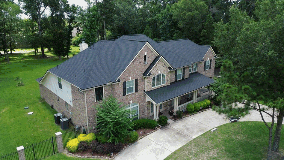 Aerial view of completed dark shingle roof on residential home