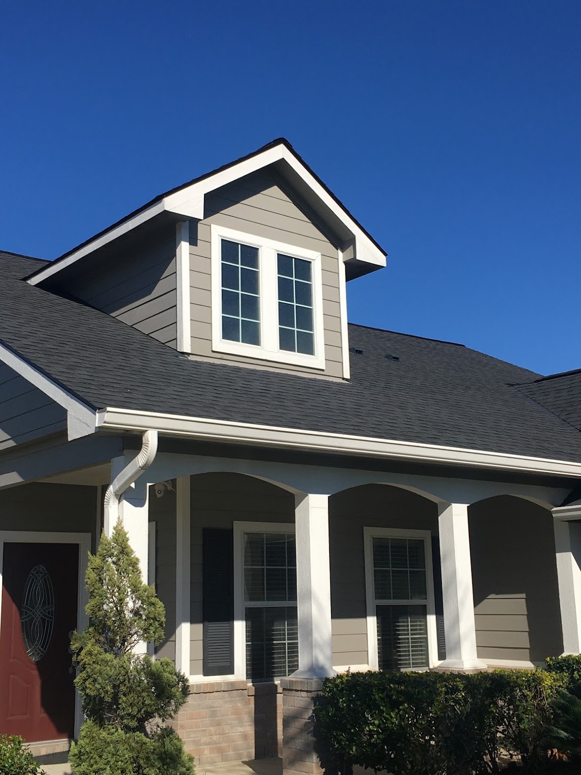 Completed dark shingle roof on modern grey craftsman-style home