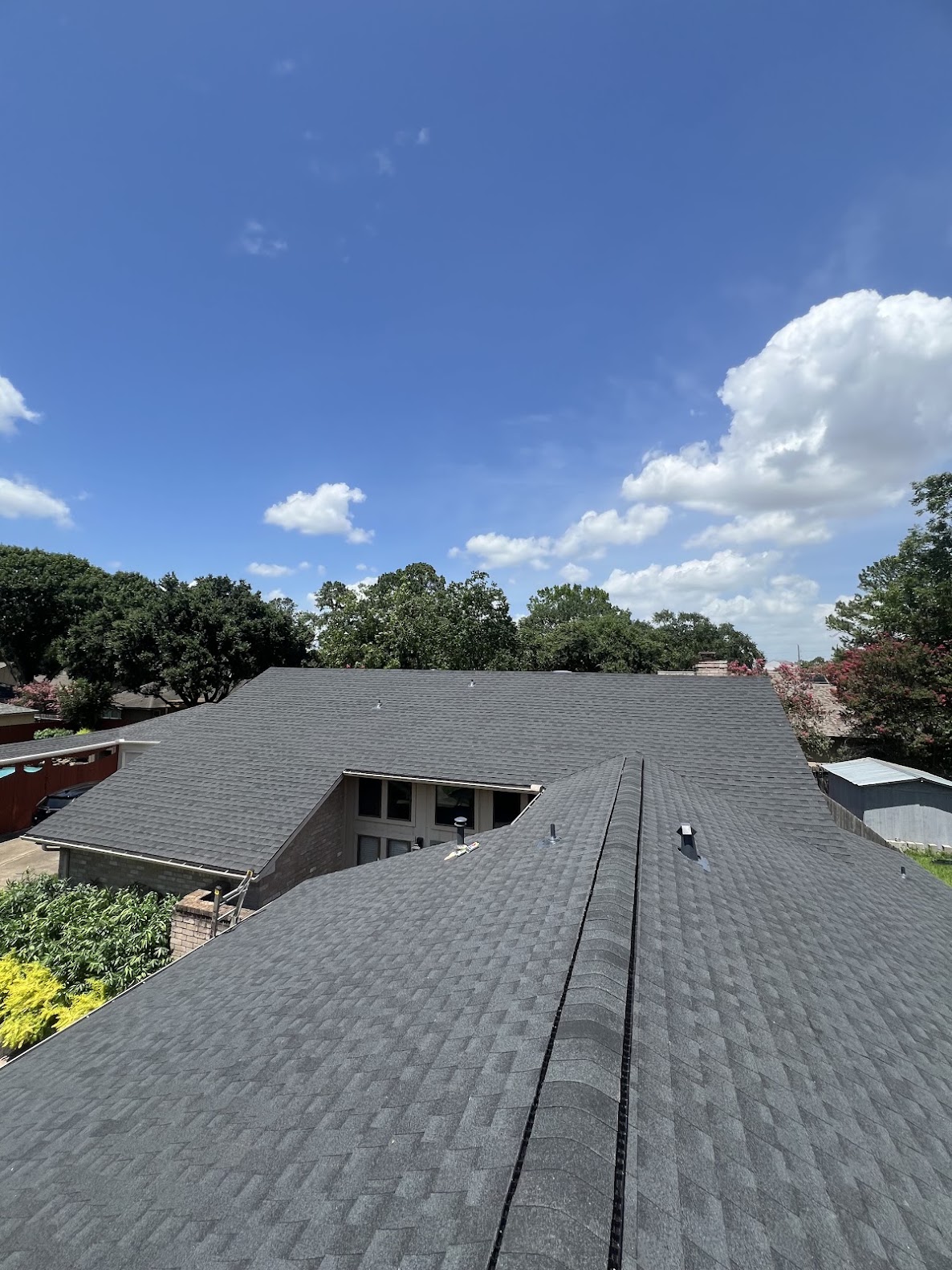 Completed residential shingle roof with multiple planes viewed from roofline